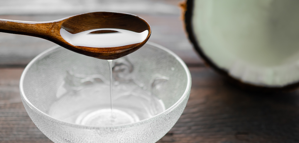 冷压椰子油木匙。由nature on wooden background. pure white oil. herb and food for good health or for massage aroma therapy. Thailan herbal and tropical fruit. raw food.